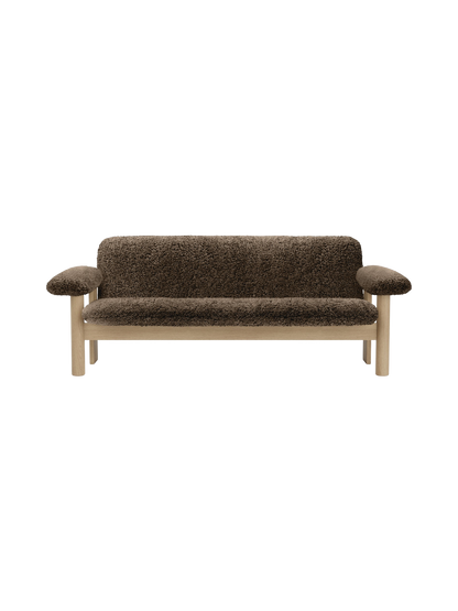 A front view of the two-seater Brasilia Sofa, upholstered in dark brown sheepskin with a solid natural oak frame.