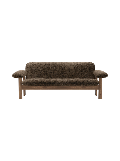A front view of the Brasilia Sofa in dark brown sheepskin. The sofa features a wooden frame with rounded legs and arms.