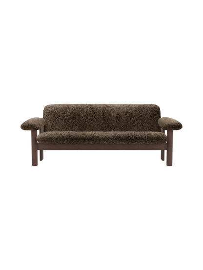 Front view of the Brasilia Sofa, Sheepskin. The two-seat sofa features a dark stained wooden frame and dark brown sheepskin.