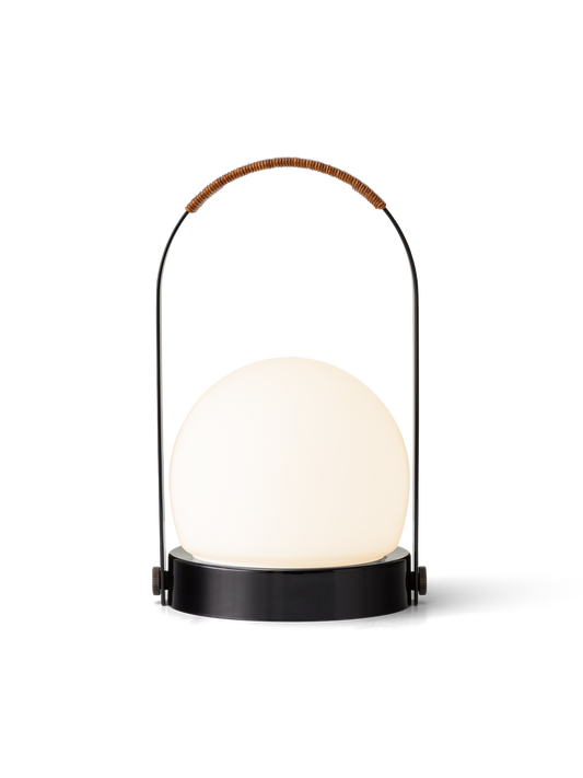 Carrie Portable Lamp featuring a glowing opal glass shade and black arched handle with a brown leather cord detail.