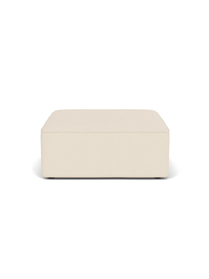 Front view of the Eave Modular Sofa, 96, Pouf. The rectangular pouf is upholstered in a light cream Logan Jasmine fabric.