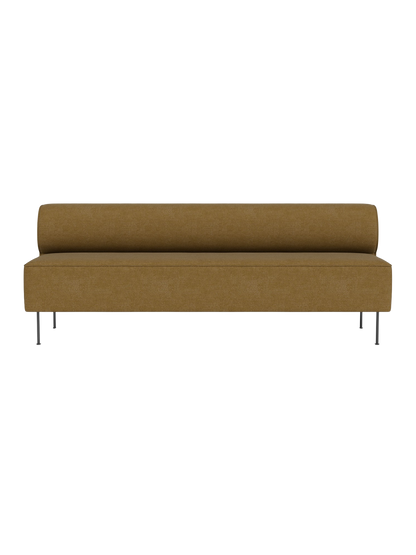 Front view of the Eave Dining Sofa. The long, armless sofa has mustard-coloured upholstery and stands on slim, metal legs.