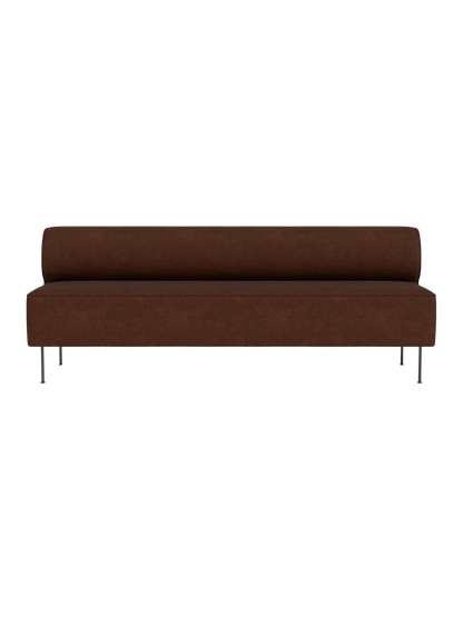 A front view of the Eave Dining Sofa. The long, armless sofa has dark brown upholstery and stands on slender metal legs.