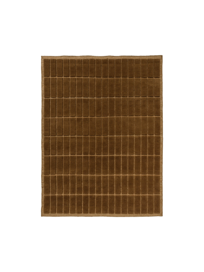 Top-down view of a square, brown rug featuring a plush, tufted grid pattern of vertical rectangles and a simple woven border.