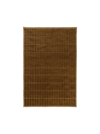 Top-down view of a square, plush rug in a warm brown colour, featuring a carved grid pattern of small, uniform rectangles.