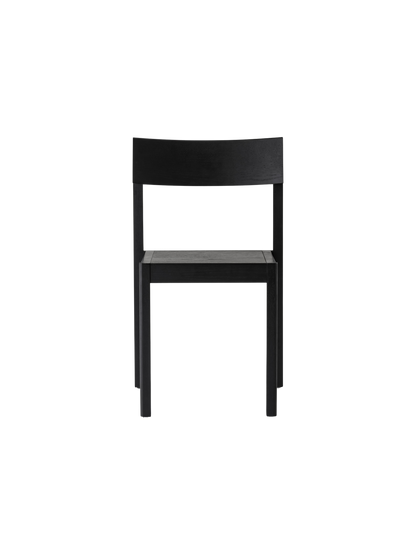 Black oak Mauro Dining Chair with a minimalist wooden frame and curved backrest against a plain white background.