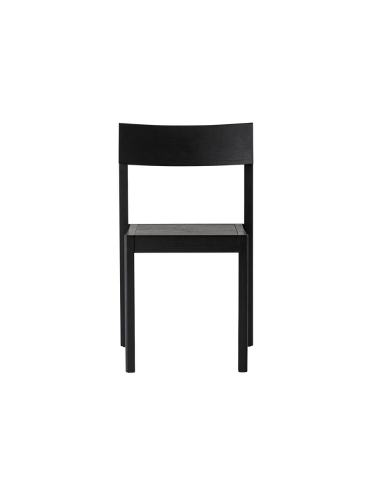 Black oak Mauro Dining Chair with a minimalist wooden frame and curved backrest against a plain white background.