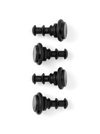 Overhead view of four black, ribbed rubber plugs for the Passage Stool, lined up on a white background.