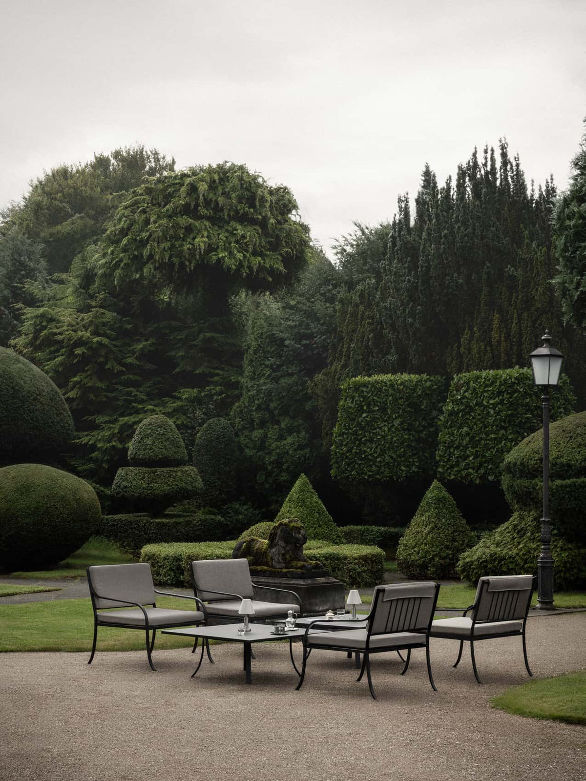 Bloss Garden Lounge Chair and Cushion Set paired with the Bloss Garden Lounge Table and Admiral Portable Lamp outdoors.