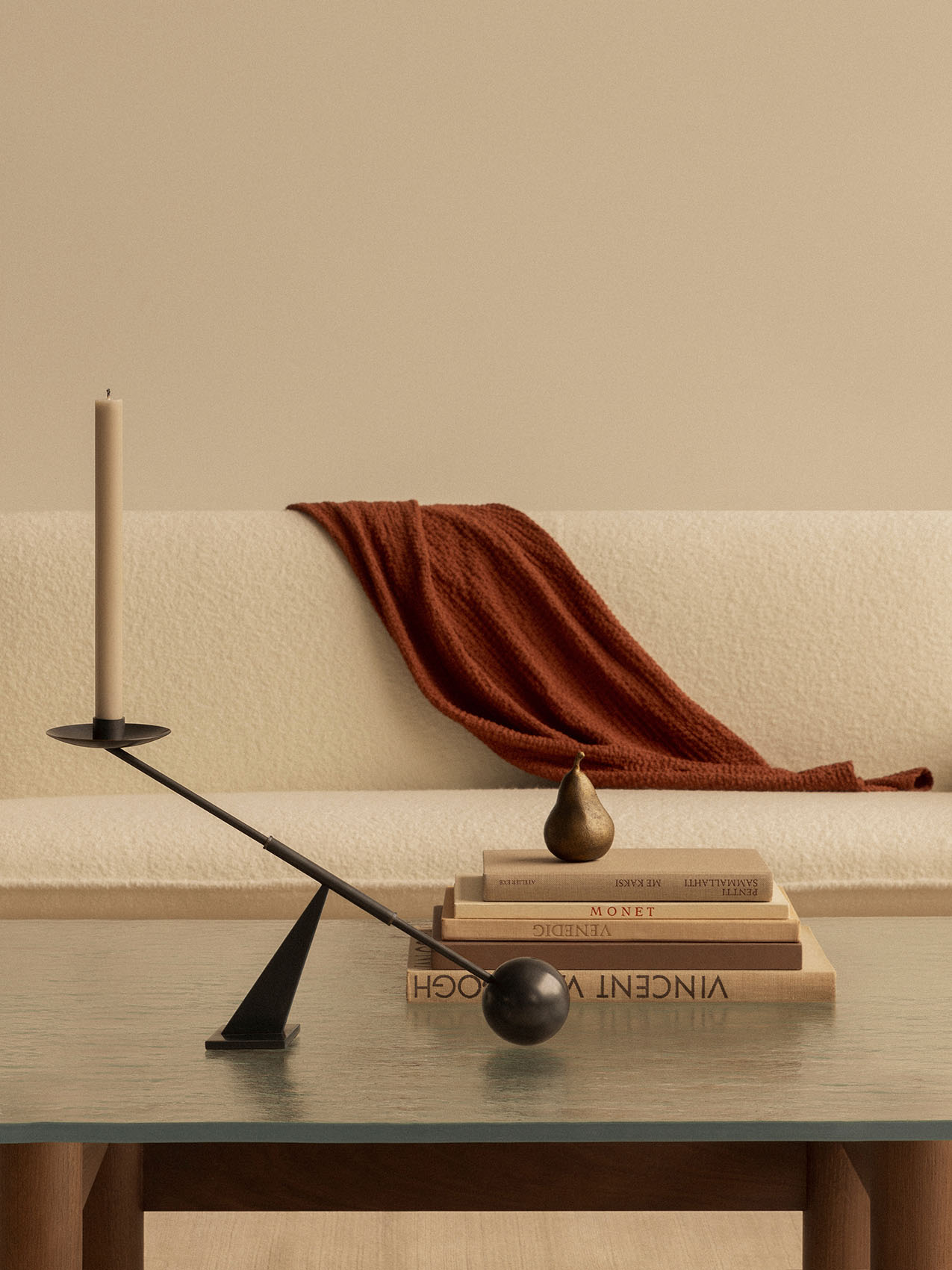The black Interconnect Candle Holder on a glass-topped Brasilia Lounge Table, with the cream Brasilia Sofa in the background.