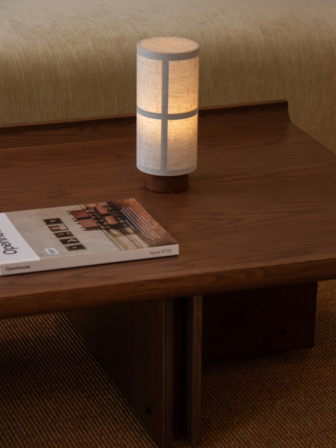 Conrad Lounge Table in dark stained oak veneer featuring an upward-curving border, styled with a portable lamp and magazine.