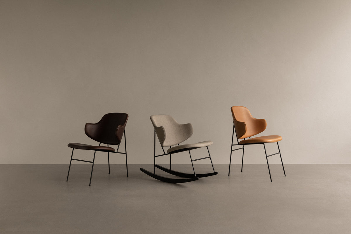 Three modern shell chairs in dark brown leather, light grey fabric rocking