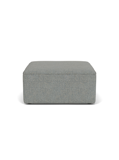 Front view of the Eave Modular Sofa, 86, Pouf upholstered in a textured light blue Safire fabric, against a black background.