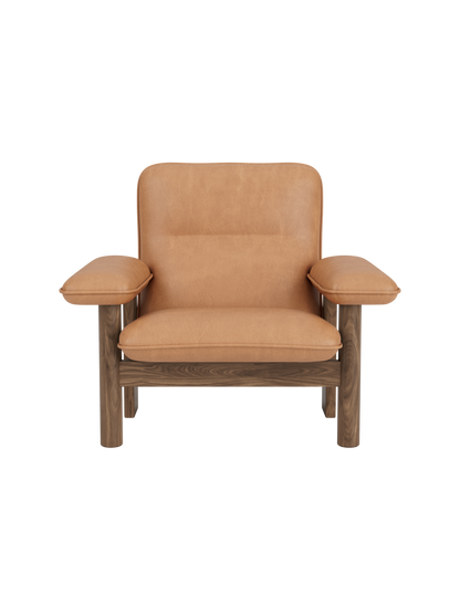 Front view of the Brasilia Lounge Chair in walnut with plush, camel leather upholstery, shown against a black background.