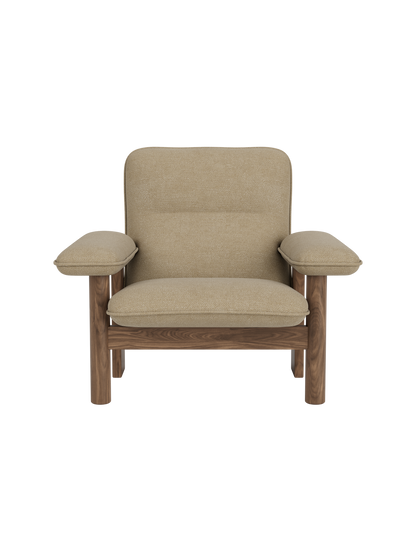 Front view of the Brasilia Lounge Chair with a walnut frame and beige Audo Bouclé 02 upholstery on a black background.