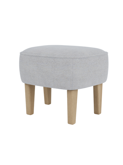 The Ingeborg Ottoman viewed from a three-quarter angle, upholstered in light grey Fiord 751 with natural oak legs.