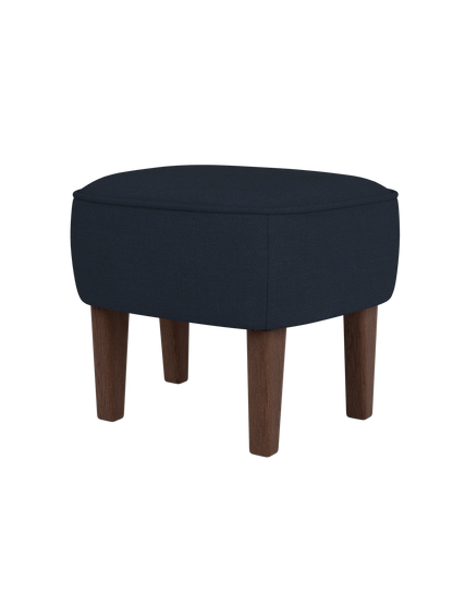 The Ingeborg Ottoman, upholstered in dark blue Fiord 782 fabric with smoked oak legs, shown against a plain black background.