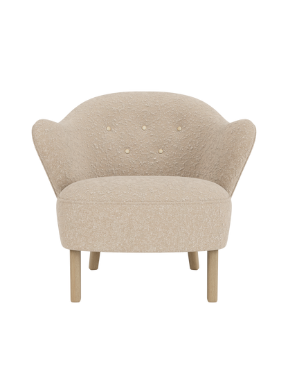 Front view of the Ingeborg Lounge Chair, light beige textured upholstery, button-tufted back and natural oak legs.
