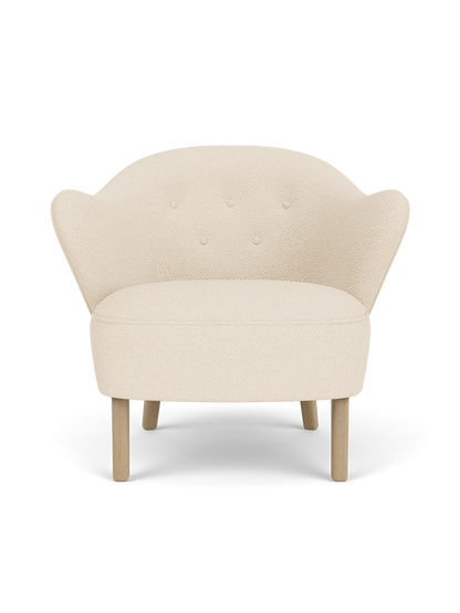 Ingeborg Lounge Chair in Logan Jasmine textile with natural oak legs and a curved, button-tufted backrest.