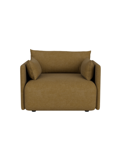 Front view of the Offset Sofa, a one-seater armchair upholstered in mustard Audo Bouclé 06 fabric, on a black background.