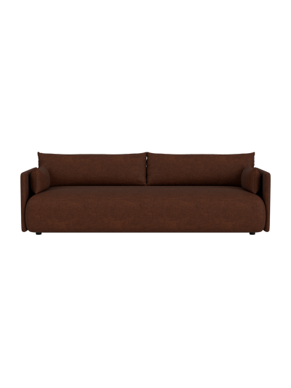 Front-on view of the Offset Sofa, a three-seater upholstered in warm brown bouclé fabric, against a black background.