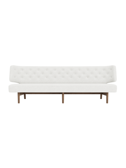 Front view of the Radiohus Sofa P3 with white, button-tufted upholstery and a dark walnut frame on a black background.