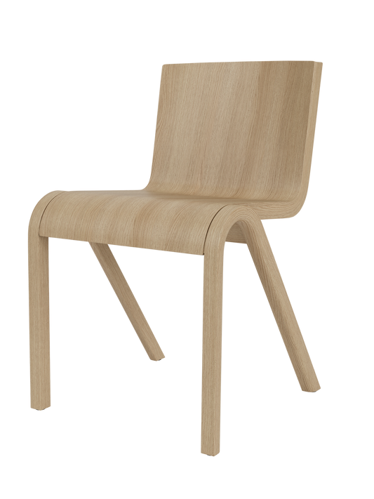 A Ready Dining Chair in natural oak from a side angle on a black background, highlighting its continuous curved form.
