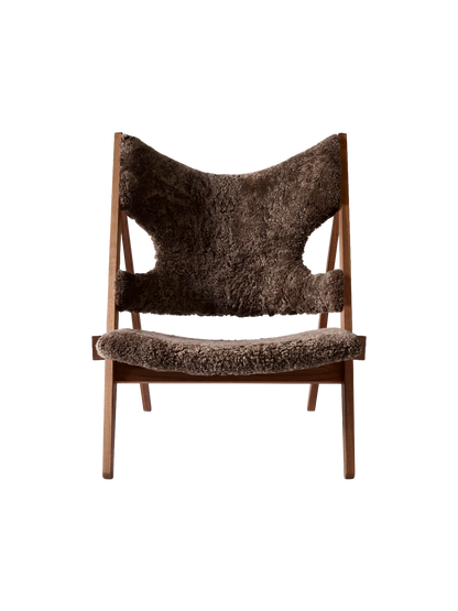 Front view of the Audo CPH Knitting Lounge Chair, featuring plush, dark brown 'Root' sheepskin upholstery on a walnut frame.