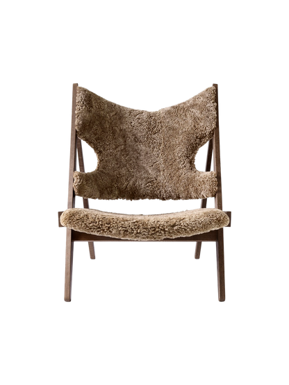A front-on view of the Knitting Lounge Chair. The chair has a dark stained oak frame and light brown Sahara sheepskin seat.