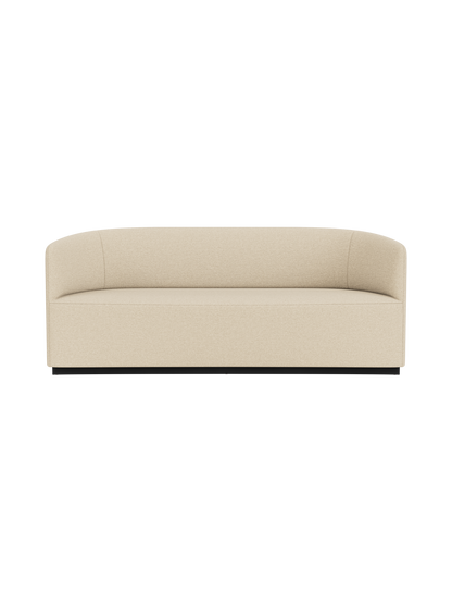 A front-on photograph of the Tearoom Sofa upholstered in a light beige Logan Sand fabric, set against a black background.
