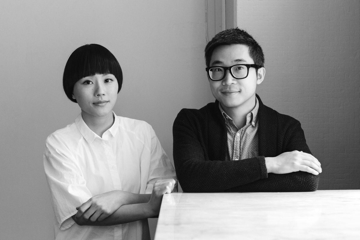 Black and white portrait of the designers Afteroom Studio, Hung-Ming Chen and Chen-Yen Wei, posing together indoors.