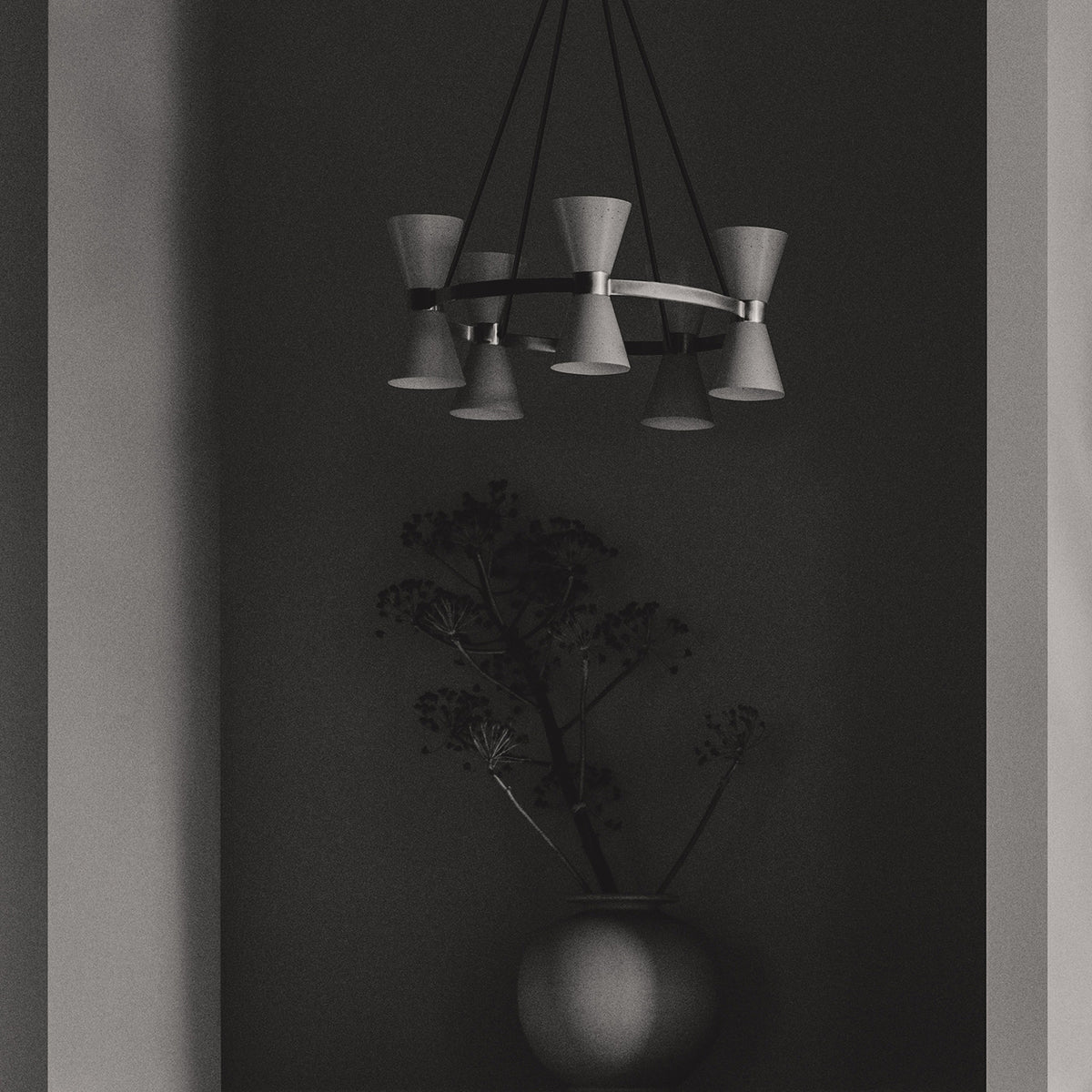 Alf Svensson chandelier featuring conical shades arranged on a circular metal frame, hanging above a decorative vase.