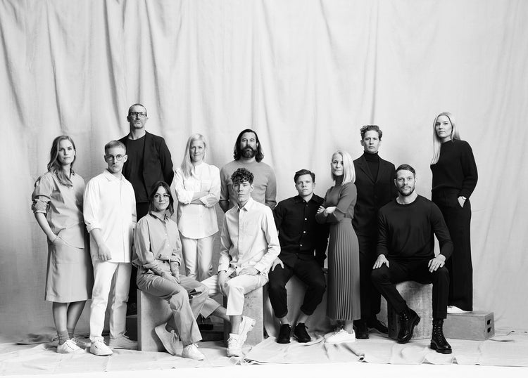 Black and white portrait of the Note Design Studio team gathered together in front of a textured fabric backdrop.