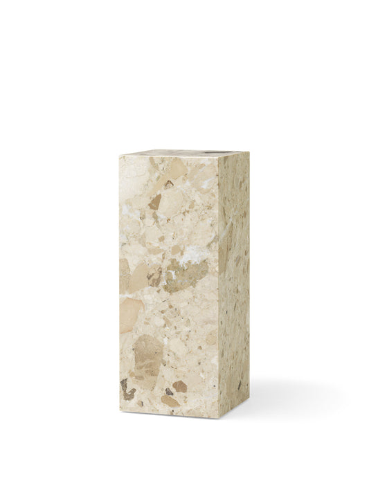The Plinth Pedestal in Kunis Breccia marble, shown from an angle. The stone features light beige and earthy-toned fragments.