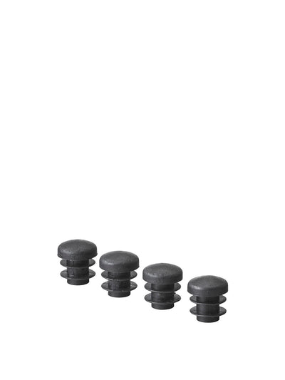 Four black plastic ribbed inserts for furniture legs, shown in a row against a plain white background.