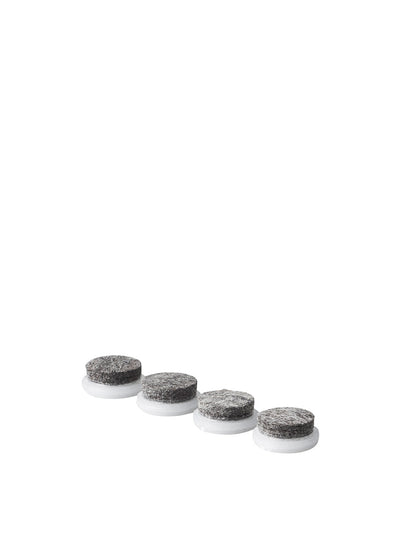 Four round grey felt furniture pads with white plastic bases arranged diagonally on white background